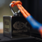 Magnetar Mega Cube Neodym-Bergemagnet mit orangefarbenem Seil befestigt, extrem stark für professionelles Magnetfischen.