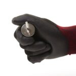 Neodym-Topfmagnet mit Öse in schwarzer Arbeitshandschuh-Hand gehalten, kompakte Lifestyle-Abbildung für Magnetfischen und Werkstatt.