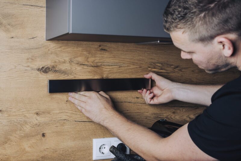 Montagefoto einer magnetischen Messerleiste, die an einer Küchenwand angebracht wird – praktische Lösung für Messeraufbewahrung.